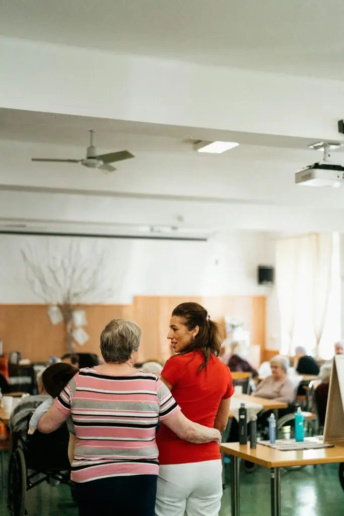 A warm moment between a caregiver and senior in a community center.