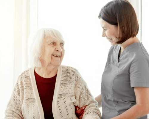 caregiver dressed in grey with elderly woman