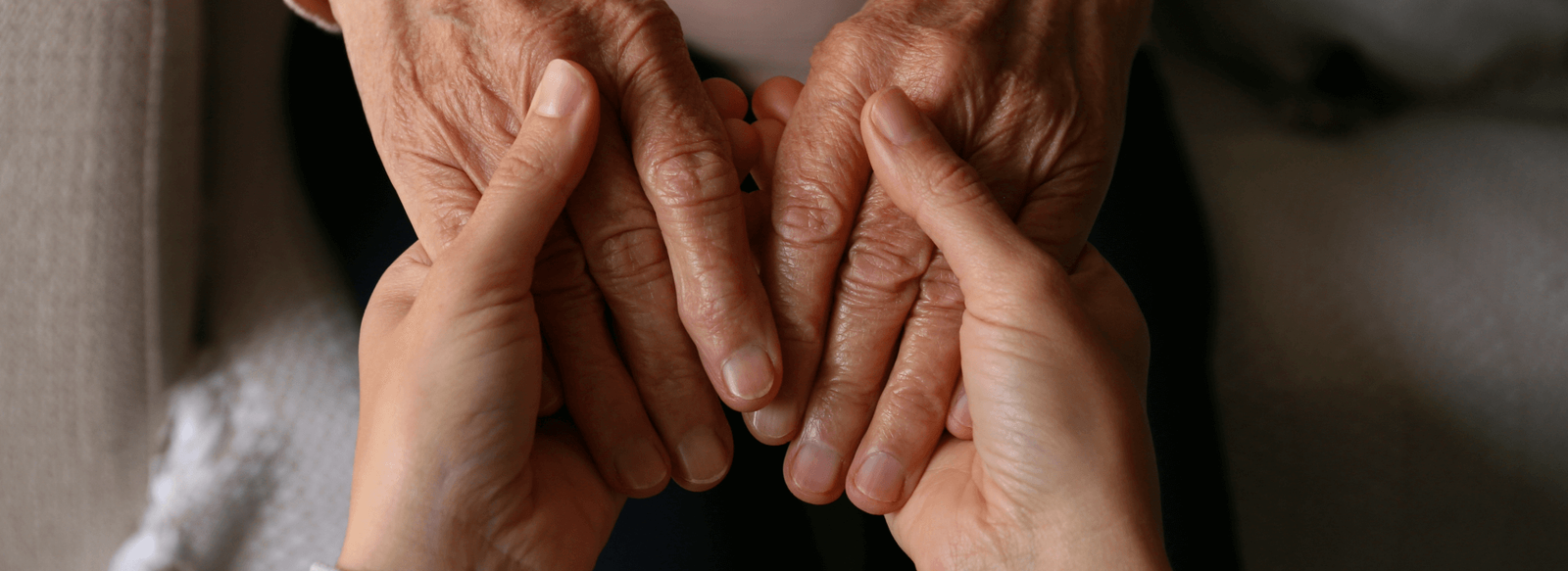 elderly holding hands with caregiver