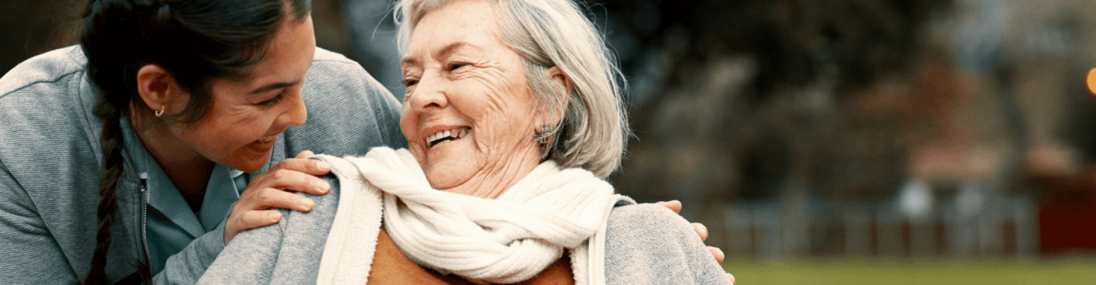 elderly woman smiling with caregiver